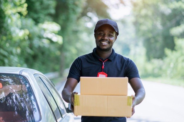 sourire male africain courrier livreur messager devant voiture livraison colis 73622 995